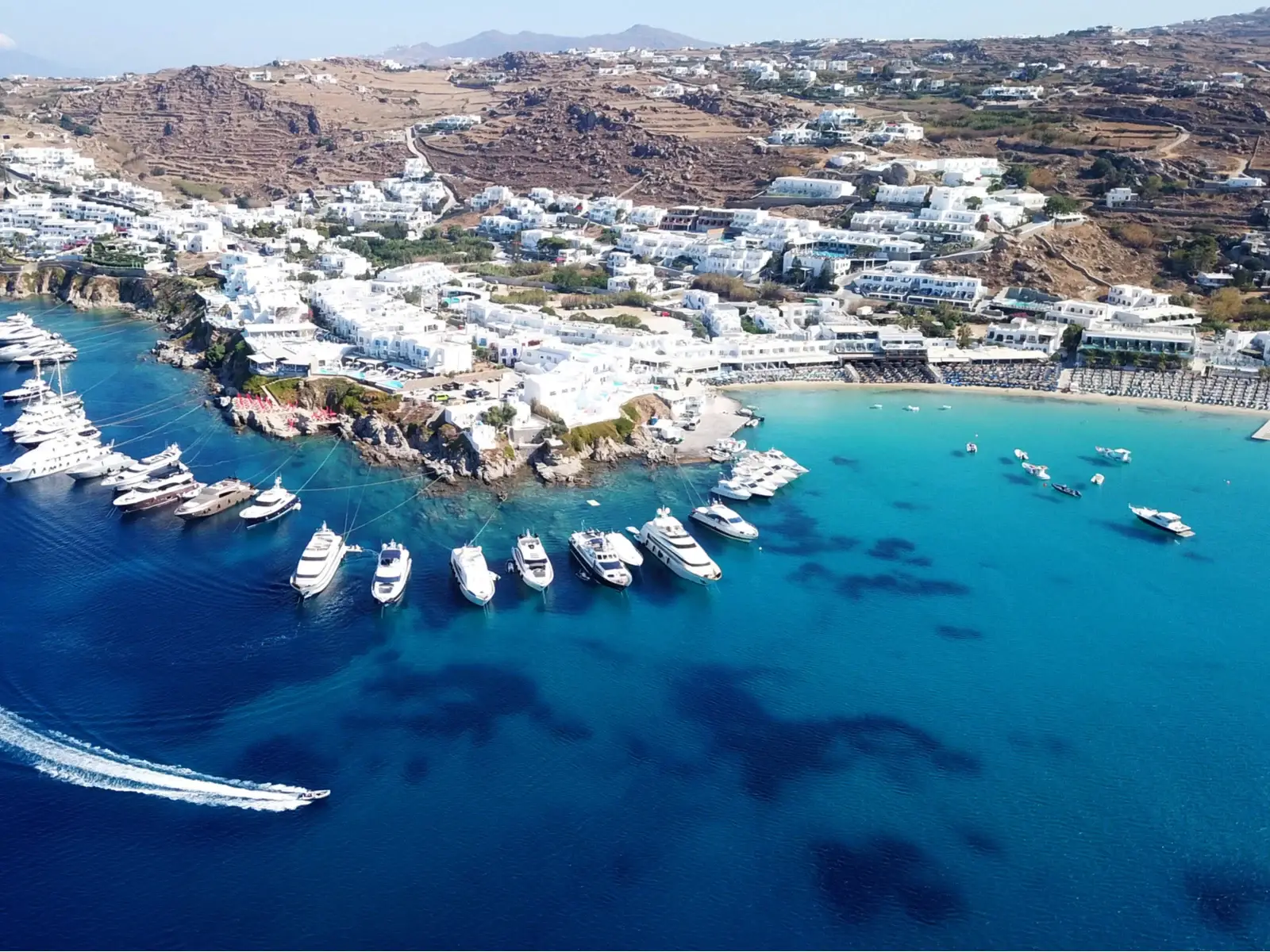 Platys Gialos, Mykonos, one of Greece's best beaches, seen from a drone shot with boats around the coast