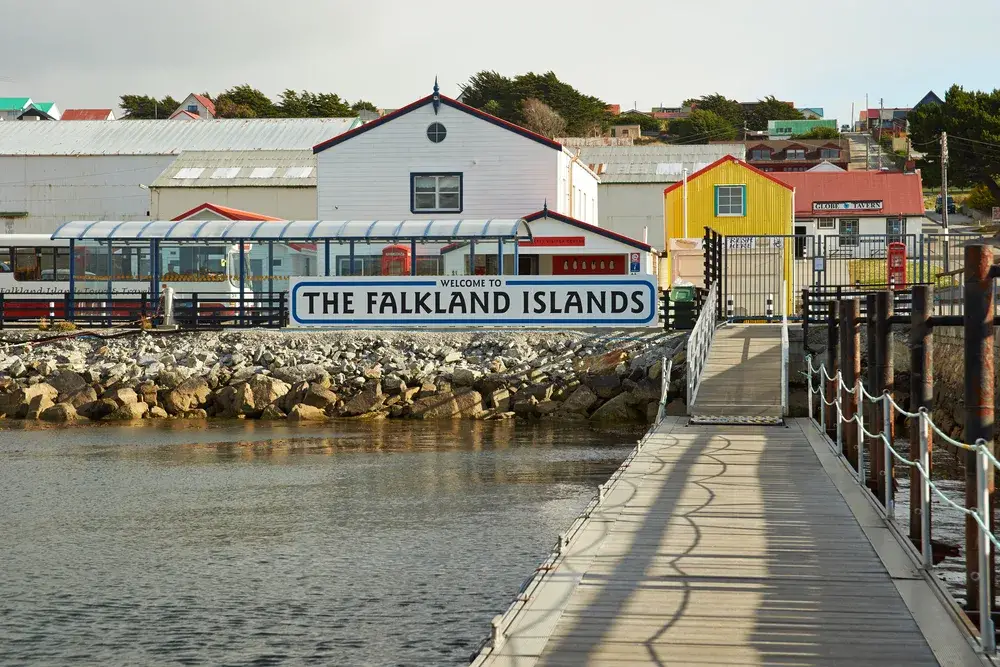 Sign that says Welcome to the Falkland Islands pictured at the end of a jetty in the harbor of Stanley