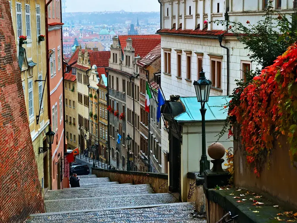 Gorgeous buildings on either side of a narrow walkway with stone steps and old-time lampposts for a piece on whether Prague is safe for tourists