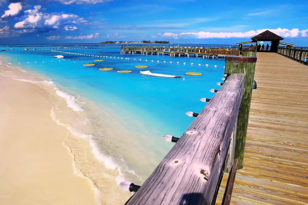 Pier jutting out into the blue ocean at Cable Beach during the overall best time to go to Nassau