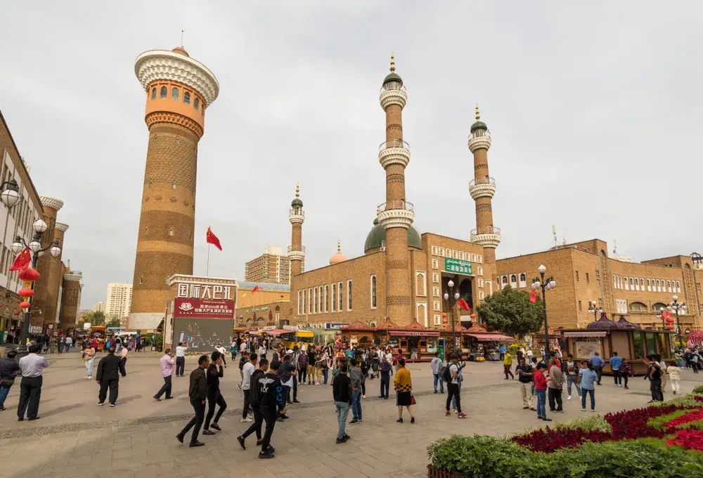 Large building in the Xinjiang Uyghur Autonomous Region, one of the least safe places to visit in China, featuring large minarets towering over the town square