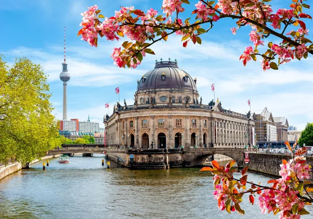 Museum Island view with pink blossoms on a tree in the foreground during the best time to visit Berlin