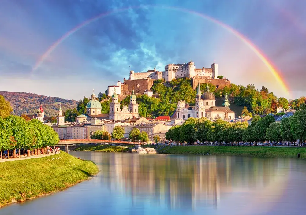 Rainbow over the Salzburg Castle in Salzburg, one of the best places to visit in Austria, as seen from the river