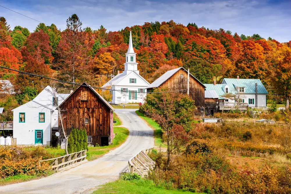 Rural Vermont pictured in autumn, the least busy time to visit New England, with red and brown leaves on the trees