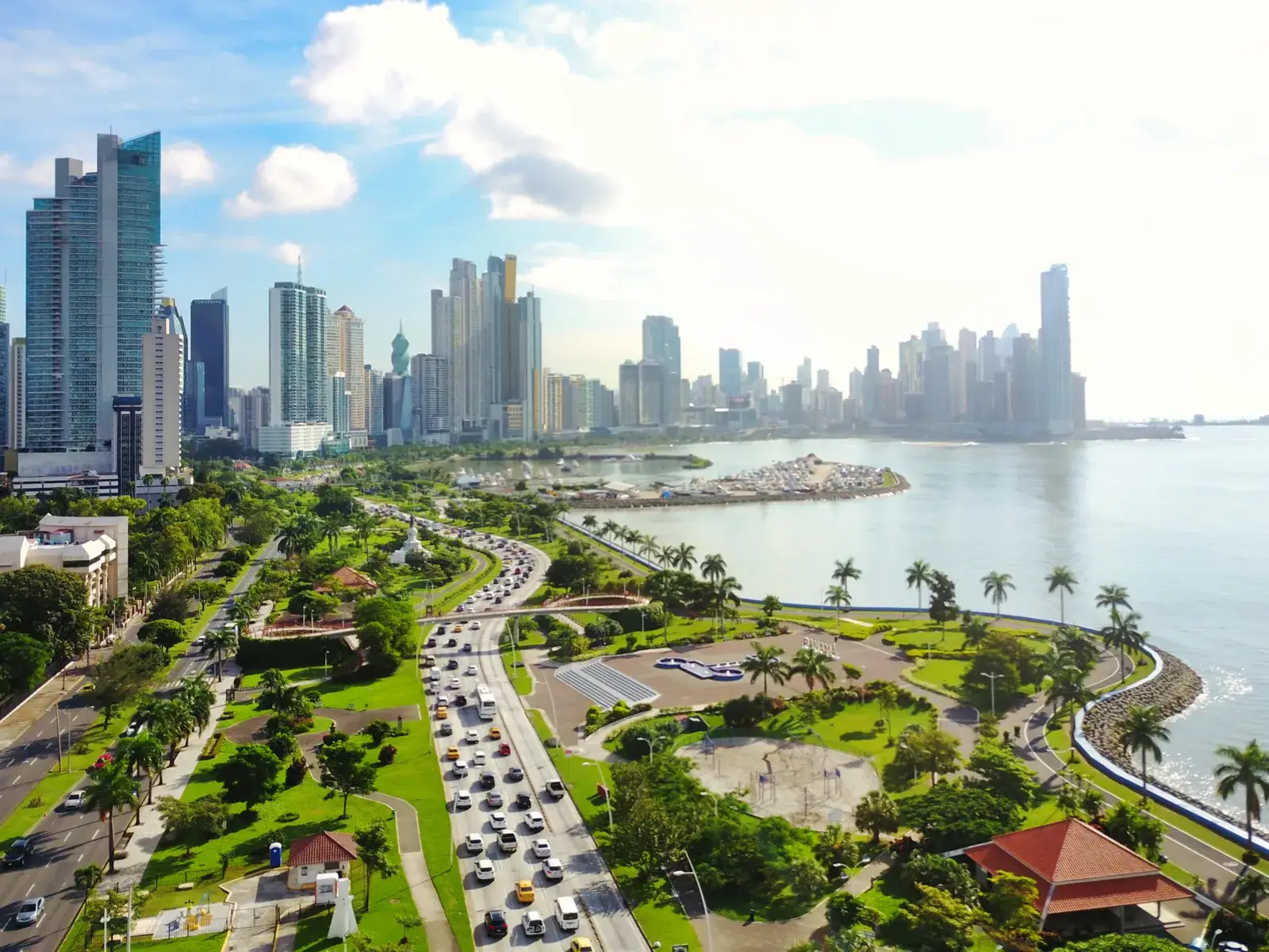 Modern skyline with lots of greenery and parks alongside skyscrapers and the ocean for a piece titled Is Panama Safe