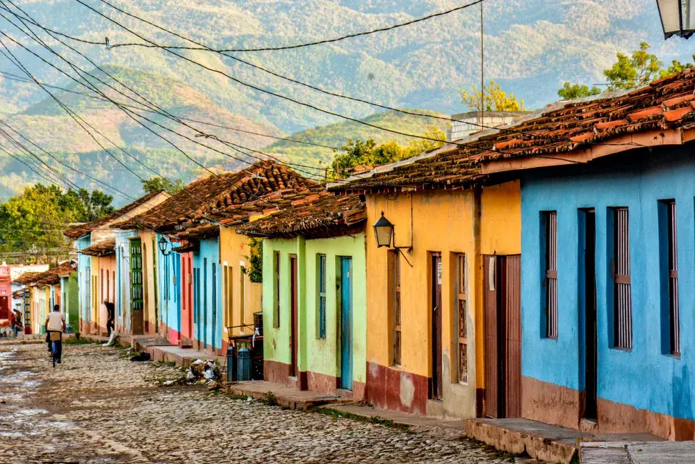 Neat and colorful homes in a row along a brick path in Trinidad, Cuba