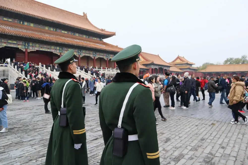 Two guards in old-time uniforms guarding the Forbidden City in China for a piece on whether or not the country is safe to visit