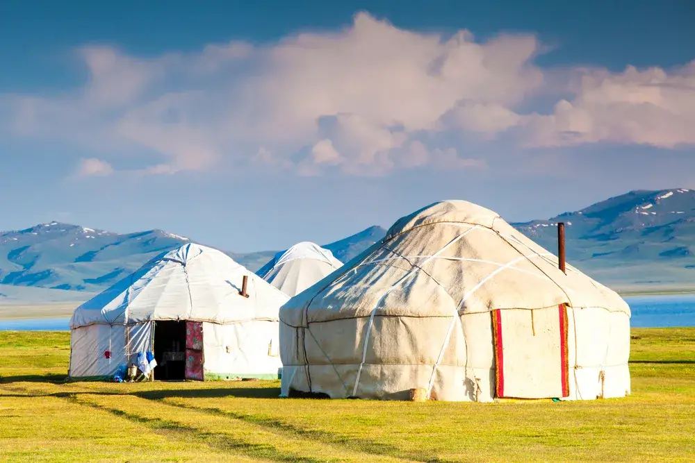 Age-old yurts of Song Kul in the alpine mountain range pictured during the best time to visit Kyrgyzstan
