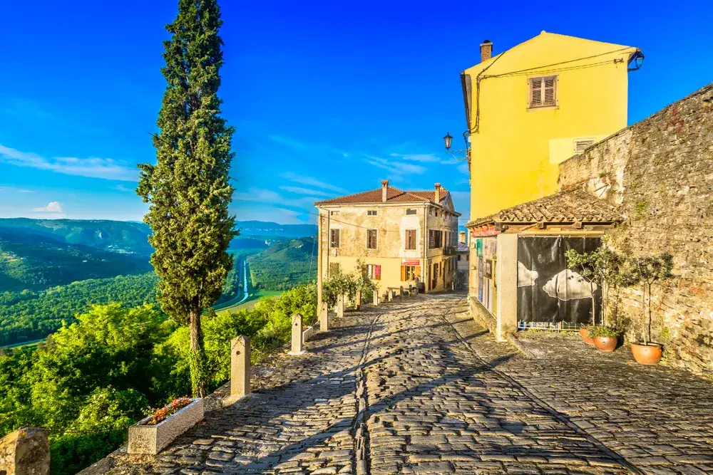 Yellow house towering over a cobblestone street in Motovun, one of the best places to visit in Croatia