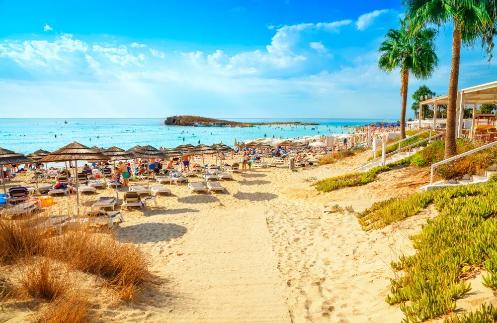 Amazing view of crystal-clear teal water by a beige sand beach pictured during the best time to visit Cyprus